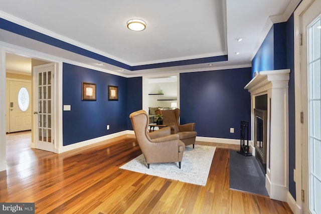 6034 Burnside Landing Dr, Burke, VA 22015 - sitting room featuring a fireplace, wood finished floors, a raised ceiling, baseboards, and crown molding