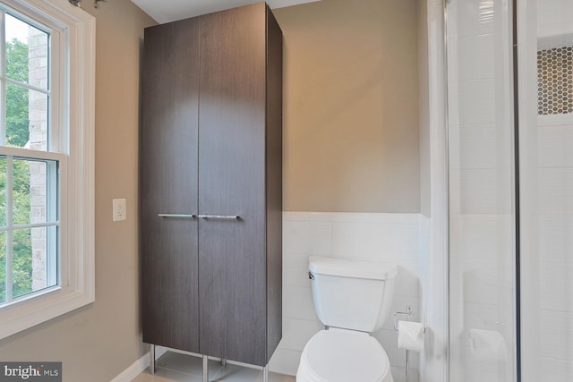 6034 Burnside Landing Dr, Burke, VA 22015 - bathroom with healthy amount of natural light, toilet, a shower, and a wainscoted wall