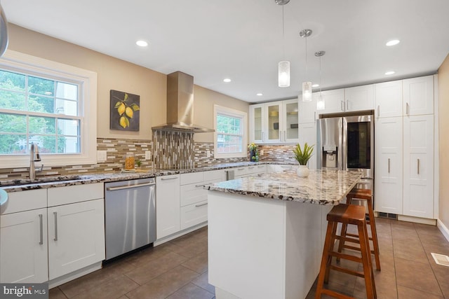 6034 Burnside Landing Dr, Burke, VA 22015 - kitchen featuring appliances with stainless steel finishes, wall chimney range hood, a sink, dark tile patterned flooring, and backsplash