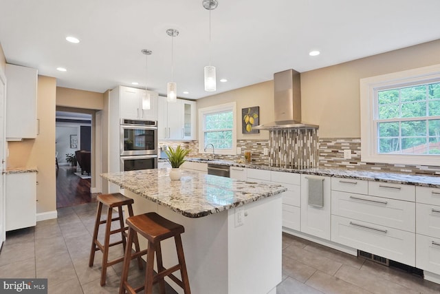 6034 Burnside Landing Dr, Burke, VA 22015 - kitchen with ventilation hood, light tile patterned floors, decorative backsplash, appliances with stainless steel finishes, and a breakfast bar area