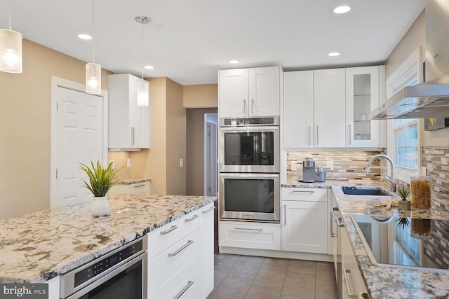 6034 Burnside Landing Dr, Burke, VA 22015 - kitchen with stainless steel double oven, black electric stovetop, a sink, light stone countertops, and decorative backsplash