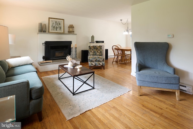 1581 W Branch Rd, State College, PA 16801 - living area with a glass covered fireplace, wood finished floors, and baseboard heating