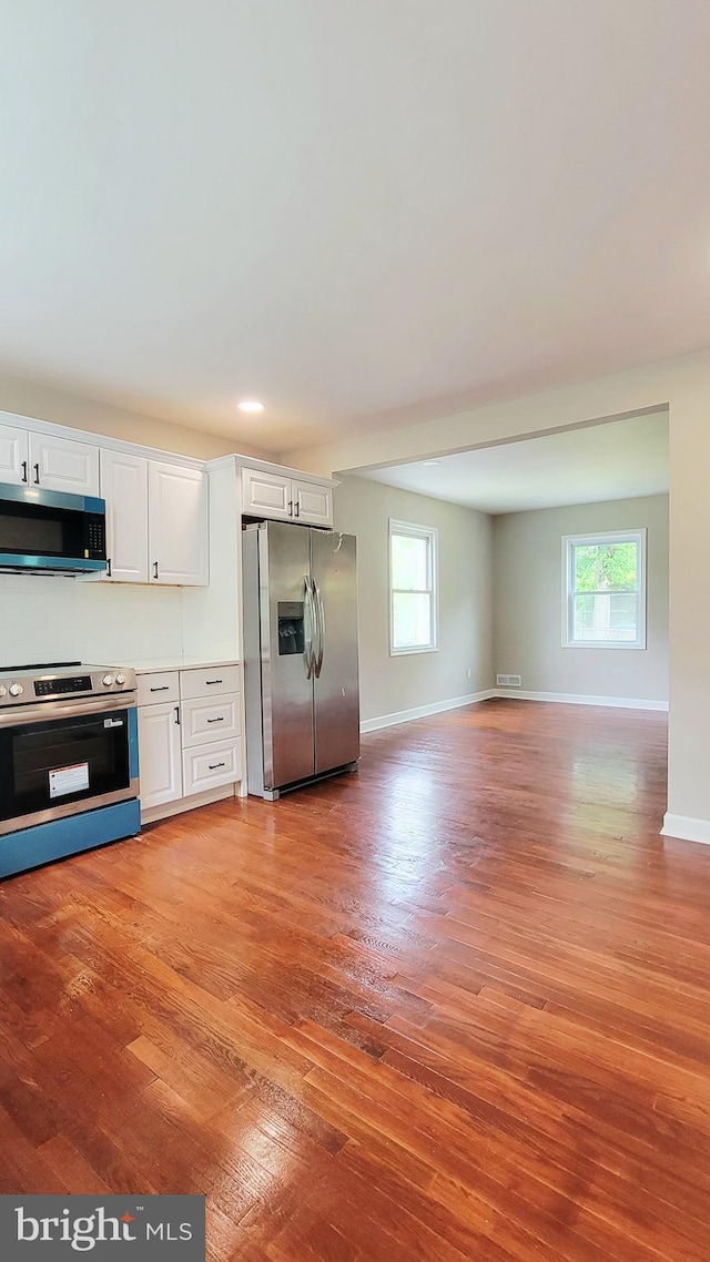 139 Wilmington Pl SE, Washington, DC 20032 - kitchen featuring stainless steel appliances, light wood finished floors, plenty of natural light, and white cabinets