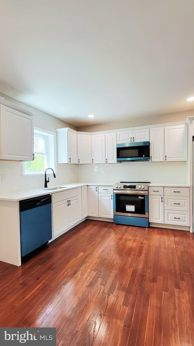 139 Wilmington Pl SE, Washington, DC 20032 - kitchen featuring appliances with stainless steel finishes, a sink, dark wood-style floors, white cabinets, and recessed lighting
