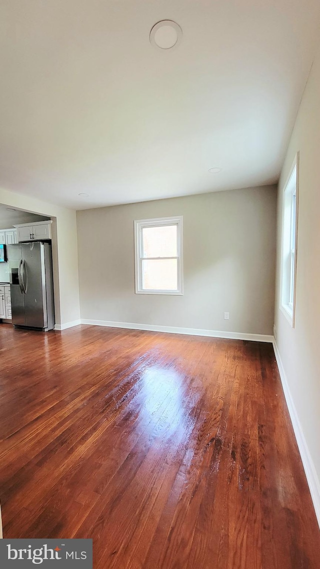 139 Wilmington Pl SE, Washington, DC 20032 - unfurnished living room with dark wood-style flooring and baseboards