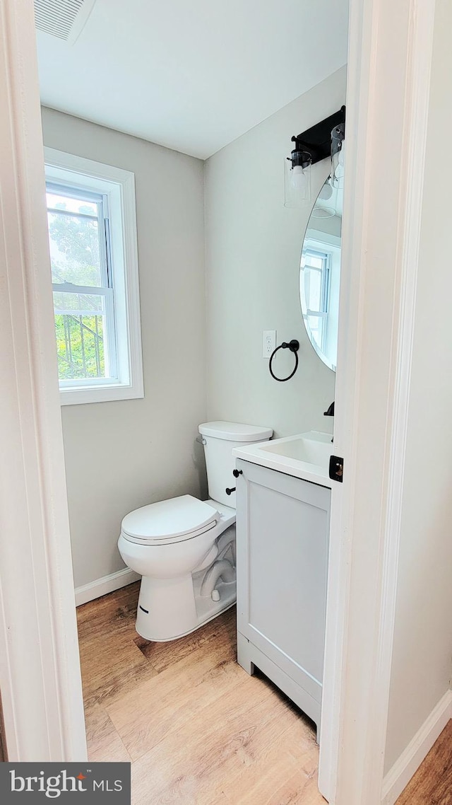 139 Wilmington Pl SE, Washington, DC 20032 - half bathroom with vanity, toilet, wood finished floors, and baseboards