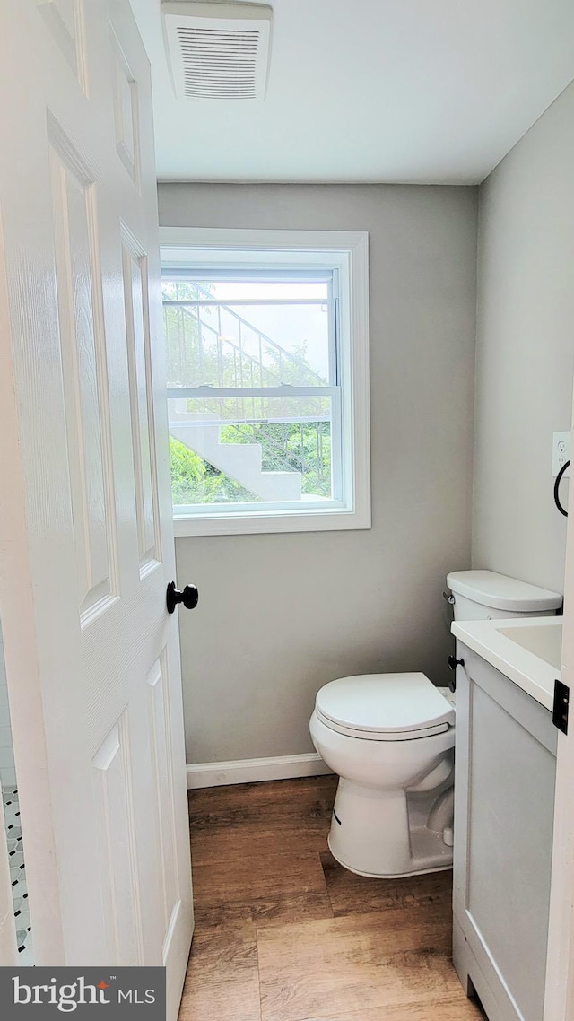 139 Wilmington Pl SE, Washington, DC 20032 - bathroom featuring toilet, vanity, wood finished floors, and baseboards