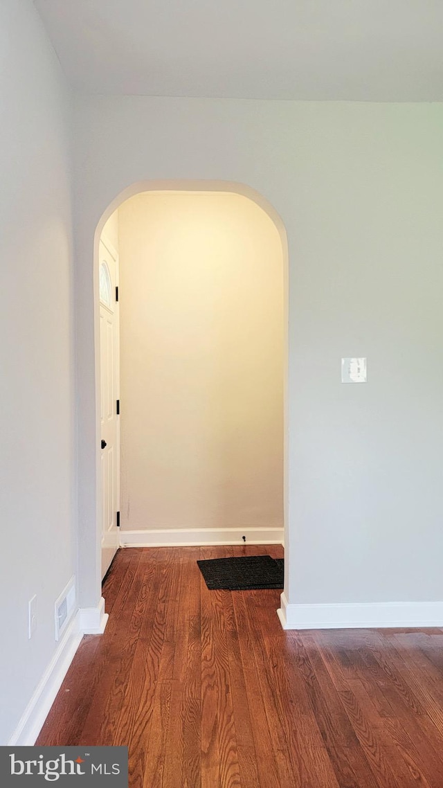 139 Wilmington Pl SE, Washington, DC 20032 - spare room featuring arched walkways, wood finished floors, and baseboards