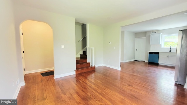 139 Wilmington Pl SE, Washington, DC 20032 - unfurnished room with arched walkways, wood finished floors, stairs, and a sink