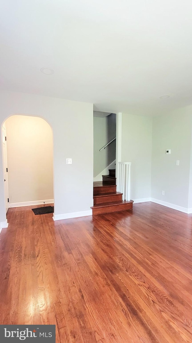139 Wilmington Pl SE, Washington, DC 20032 - unfurnished room featuring arched walkways, stairway, wood finished floors, and baseboards