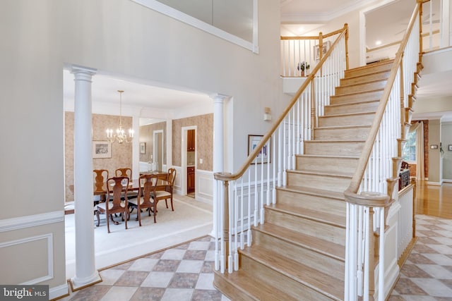 9370 Colbert Ct, Fairfax, VA 22032 - stairs featuring crown molding, a chandelier, decorative columns, a decorative wall, and wainscoting