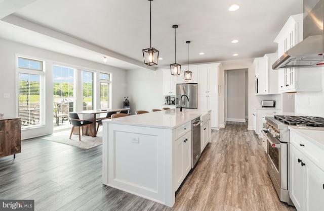220 Moorefield St, Mechanicsburg, PA 17055 - kitchen with wall chimney exhaust hood, stainless steel appliances, recessed lighting, wood finished floors, and light countertops