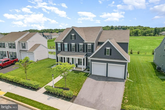 220 Moorefield St, Mechanicsburg, PA 17055 - view of front facade featuring covered porch, asphalt driveway, roof with shingles, an attached garage, and a front lawn