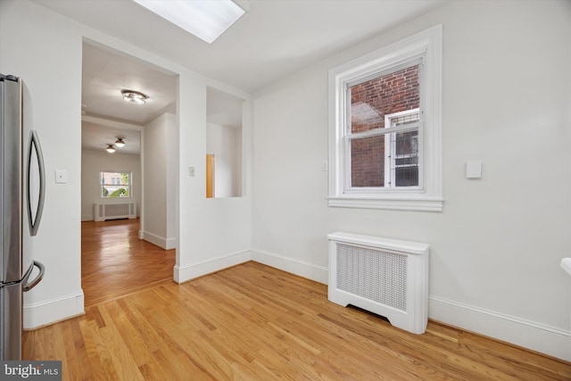 5324 Cedar Ave, Philadelphia, PA 19143 - empty room with radiator heating unit, light wood finished floors, and baseboards