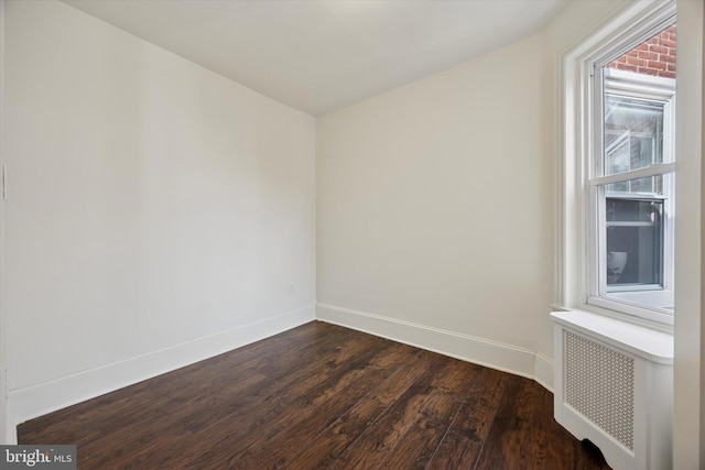 5324 Cedar Ave, Philadelphia, PA 19143 - spare room with radiator heating unit, dark wood-type flooring, and baseboards