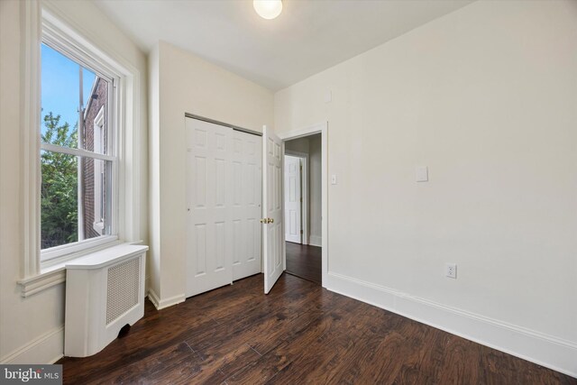 5324 Cedar Ave, Philadelphia, PA 19143 - unfurnished bedroom with baseboards, dark wood finished floors, a closet, and radiator