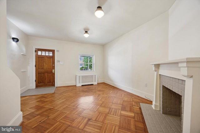 5324 Cedar Ave, Philadelphia, PA 19143 - unfurnished living room featuring radiator, baseboards, and a tiled fireplace