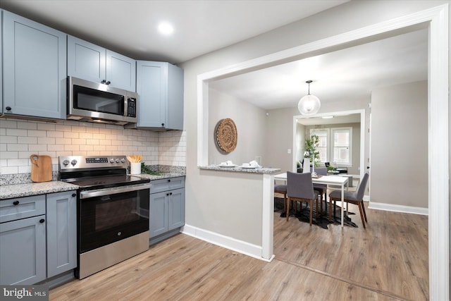 1202 Dukeland St, Baltimore, MD 21216 - kitchen featuring appliances with stainless steel finishes, baseboards, light wood-style floors, and backsplash