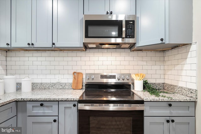 1202 Dukeland St, Baltimore, MD 21216 - kitchen featuring stainless steel appliances, decorative backsplash, and light stone counters