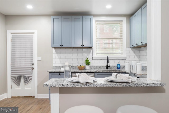 1202 Dukeland St, Baltimore, MD 21216 - kitchen with a sink, tasteful backsplash, light wood-style floors, light stone countertops, and recessed lighting