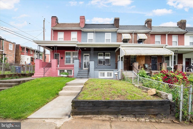 1202 Dukeland St, Baltimore, MD 21216 - townhome / multi-family property featuring covered porch, brick siding, and a chimney