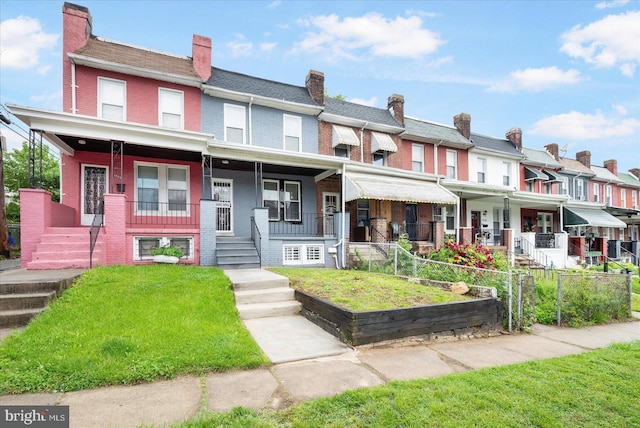 1202 Dukeland St, Baltimore, MD 21216 - view of property with a porch, a residential view, brick siding, and a front yard