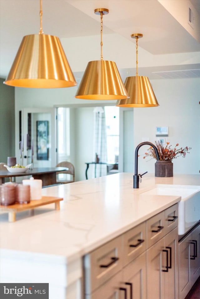 714 Iron Frg Unit A, Frederick, MD 21702 - kitchen with decorative light fixtures, light countertops, a sink, and a center island with sink