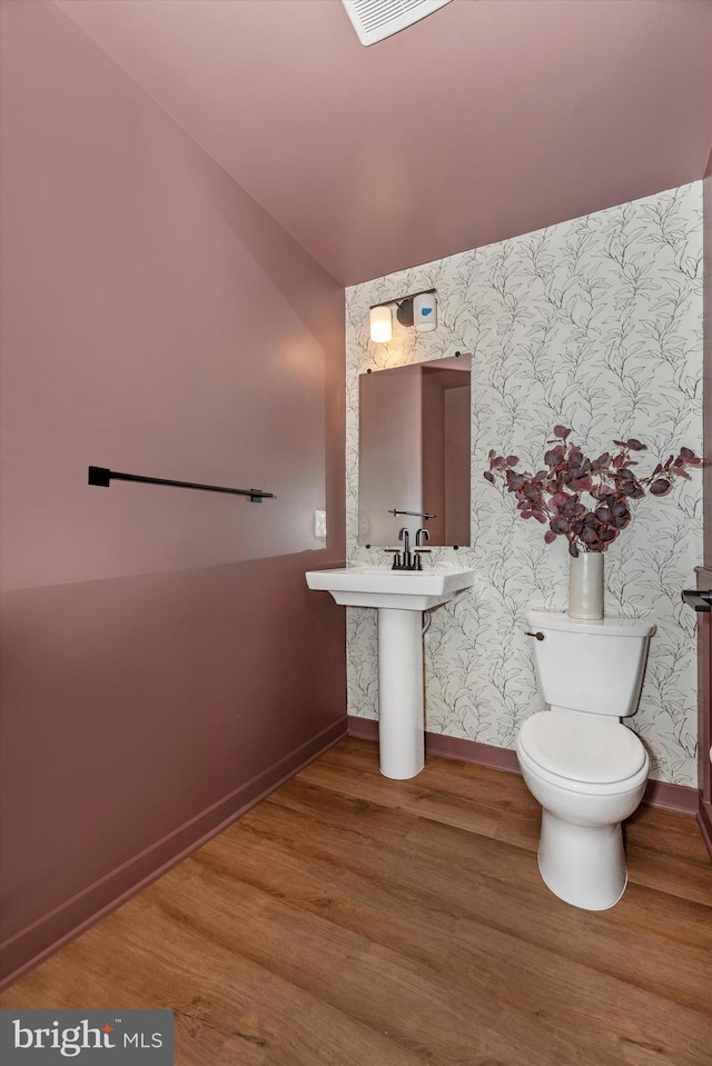 714 Iron Frg Unit A, Frederick, MD 21702 - half bathroom with baseboards, toilet, wood finished floors, wallpapered walls, and a sink