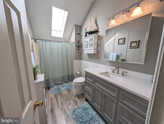 34020 Cypress Ln Unit 136, Frankford, DE 19945 - bathroom featuring a skylight, vaulted ceiling, vanity, toilet, and tile walls