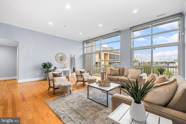 2772 Lighthouse Pt E Unit 101, Baltimore, MD 21224 - living room with light wood finished floors, baseboards, floor to ceiling windows, and recessed lighting