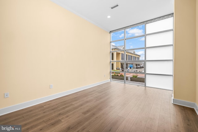 2772 Lighthouse Pt E Unit 101, Baltimore, MD 21224 - spare room featuring expansive windows, dark wood-style flooring, and baseboards