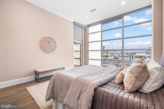 2772 Lighthouse Pt E Unit 101, Baltimore, MD 21224 - bedroom with baseboards, floor to ceiling windows, wood finished floors, recessed lighting, and crown molding