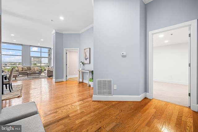 2772 Lighthouse Pt E Unit 101, Baltimore, MD 21224 - living room featuring ornamental molding, baseboards, light wood-style floors, recessed lighting, and a towering ceiling