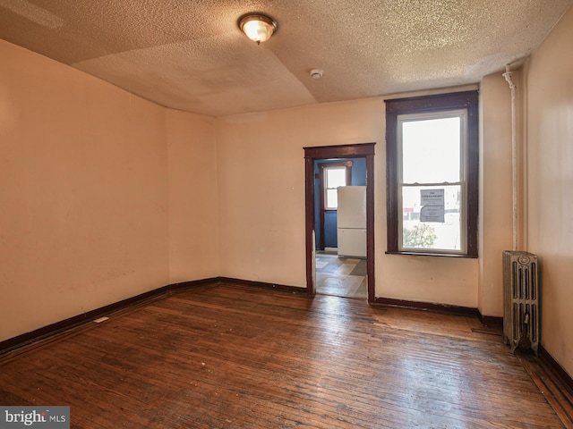 749 Bartlett Ave, Baltimore, MD 21218 - spare room with radiator, a textured ceiling, hardwood / wood-style floors, and baseboards
