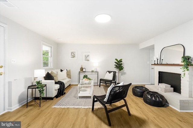 8511 Valleyfield Rd, Lutherville Timonium, MD 21093 - living area with light wood-style floors, a brick fireplace, and baseboards