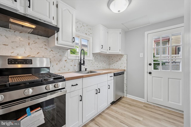 732 Thorndale Rd, Aldan, PA 19018 - kitchen featuring appliances with stainless steel finishes, wooden counters, a sink, exhaust hood, and tasteful backsplash