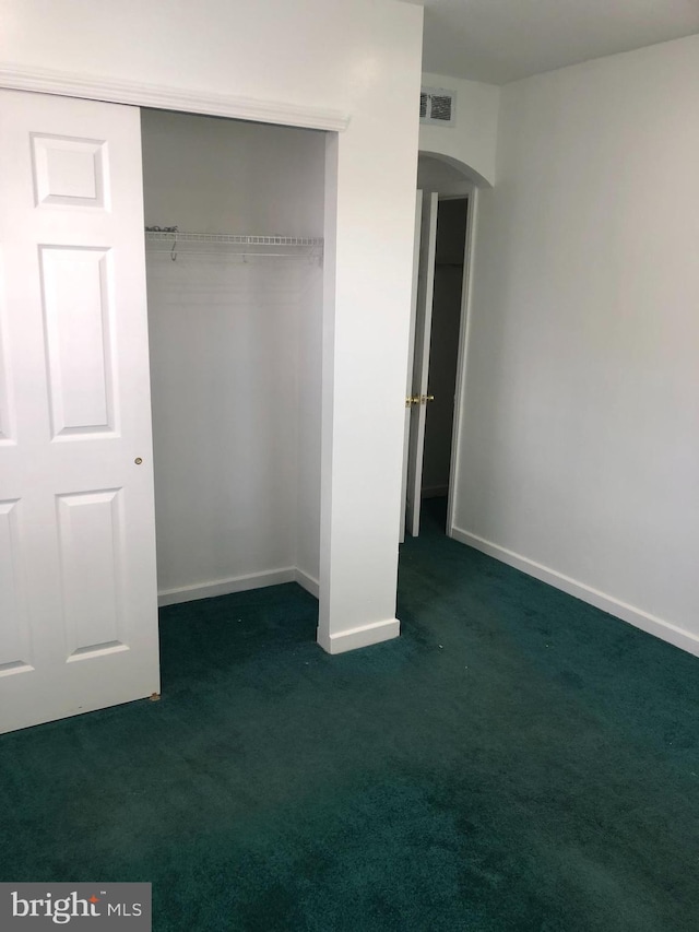 3149 Willits Rd, Philadelphia, PA 19114 - unfurnished bedroom with arched walkways, dark carpet, a closet, and baseboards