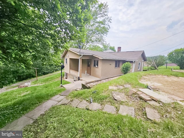 197 Coates Way, Fayette City, PA 15438 - view of side of property featuring a chimney and a lawn