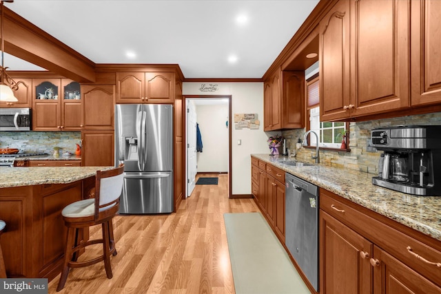 2332 Noel Cir, Pottstown, PA 19464 - kitchen with appliances with stainless steel finishes, a sink, brown cabinets, tasteful backsplash, and light wood-style flooring