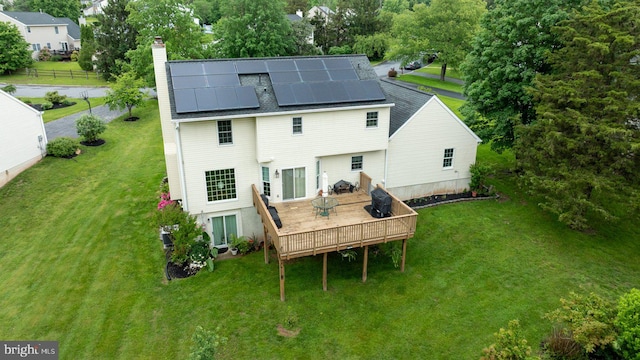 2332 Noel Cir, Pottstown, PA 19464 - rear view of house with a deck, a lawn, a chimney, solar panels, and a shingled roof