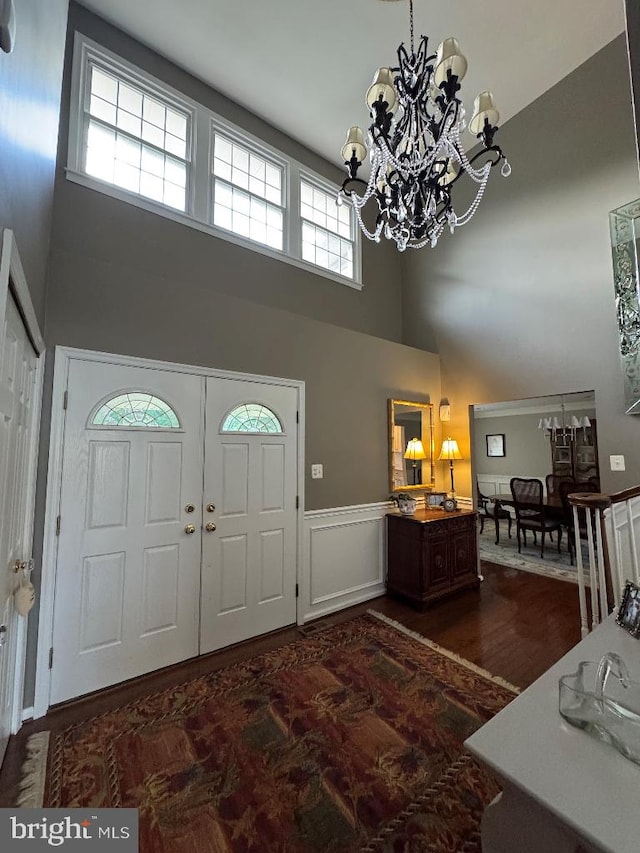 1041 Bobwhite Dr, Cherry Hill, NJ 08003 - entrance foyer with a towering ceiling, a chandelier, a wainscoted wall, and dark wood-type flooring