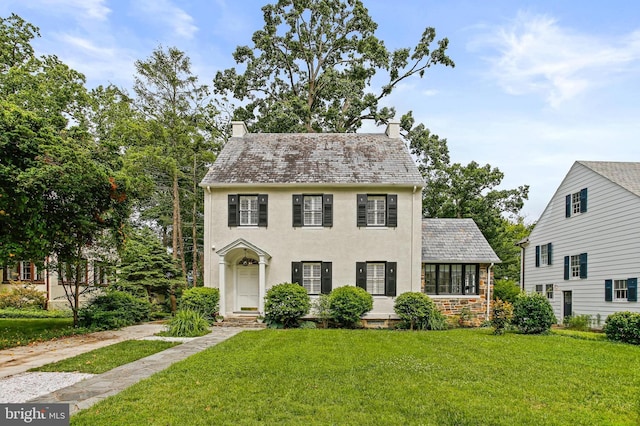 4405 Underwood Rd, Baltimore, MD 21218 - colonial house with a chimney, a front yard, a high end roof, and stucco siding