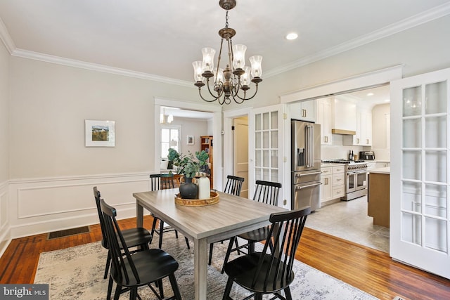 4405 Underwood Rd, Baltimore, MD 21218 - dining area with light wood-style flooring, ornamental molding, a chandelier, and recessed lighting