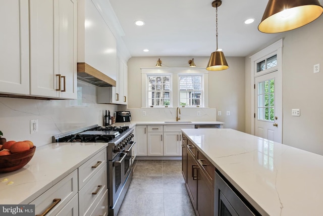 4405 Underwood Rd, Baltimore, MD 21218 - kitchen with double oven range, a sink, backsplash, white cabinetry, and recessed lighting