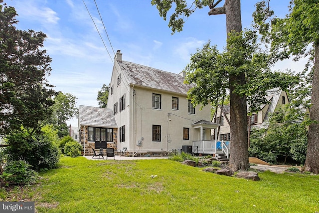 4405 Underwood Rd, Baltimore, MD 21218 - back of property with stucco siding, a chimney, a yard, a patio area, and cooling unit