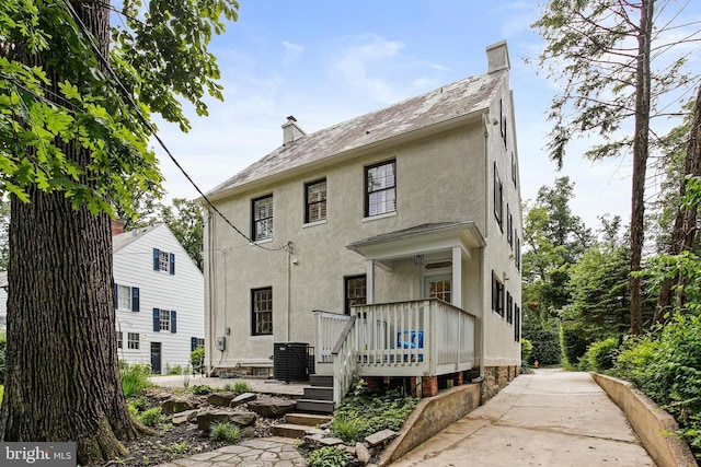 4405 Underwood Rd, Baltimore, MD 21218 - view of front of home with stucco siding, central AC unit, a chimney, and a wooden deck
