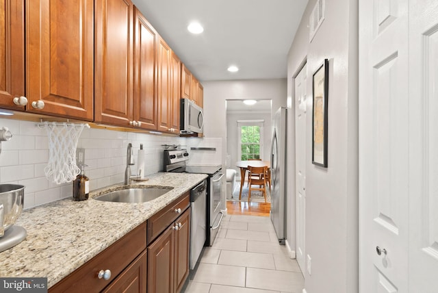 2455 Alsop Ct, Reston, VA 20191 - kitchen featuring a sink, appliances with stainless steel finishes, light tile patterned flooring, tasteful backsplash, and light stone counters