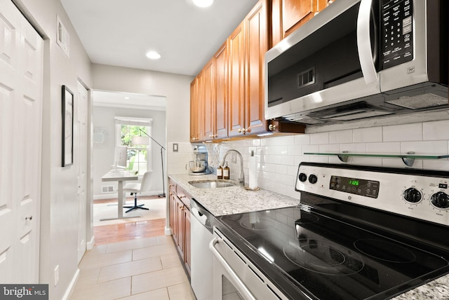 2455 Alsop Ct, Reston, VA 20191 - kitchen featuring appliances with stainless steel finishes, a sink, tasteful backsplash, light tile patterned flooring, and light stone countertops