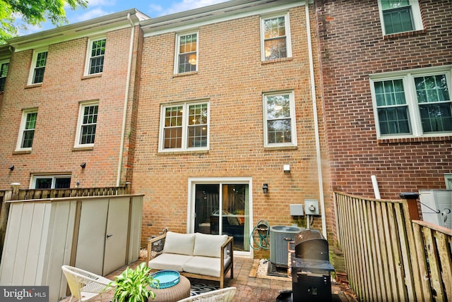 2455 Alsop Ct, Reston, VA 20191 - back of property featuring brick siding, an outdoor hangout area, central air condition unit, and a patio