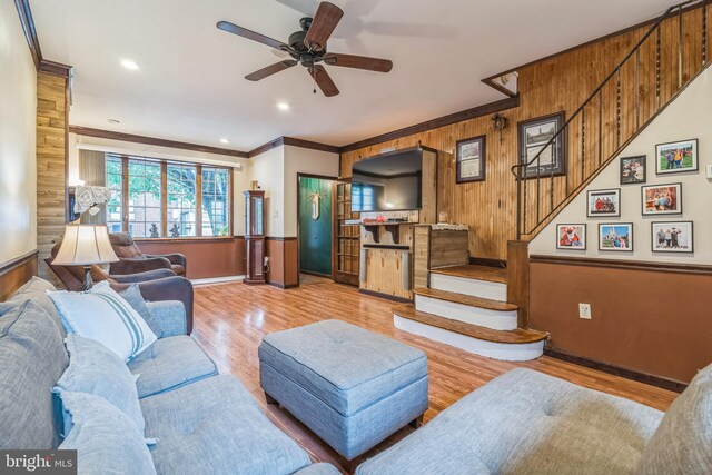 2609 E Monmouth St, Philadelphia, PA 19134 - living room with baseboards, crown molding, wood walls, stairway, and a ceiling fan